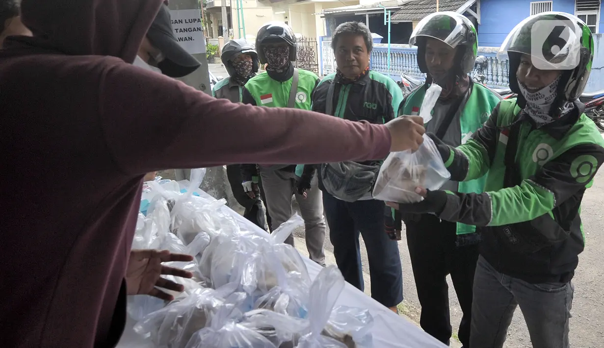 Pengemudi ojek online menerima nasi bungkus gratis di Kompleks Sinar Pamulang Permai, Pamulang Barat, Tangerang Selatan, Senin (13/4/2020). Setiap siang dan malam disediakan sekitar 100 bungkus nasi gratis oleh sekelompok warga dan pemuda Kompleks Sinar Pamulang Permai. (merdeka.com/Arie Basuki)