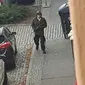 Seorang pria berjalan membawa senjata di jalanan Halle an der Saale, Halle, Jerman, Rabu (9/10/2019). Pelaku melarikan diri menggunakan mobil usai melancarkan aksinya. (Andreas Splett/ATV-Studio Halle/AFP)
