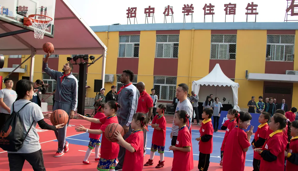 Pemain New Orleans Pelicans memberikan pelatihan kepada para siswa setalah NBA Cares Learn and Play Center di Sekolah Migran Huangzhuang, Beijing, Tiongkok (11/10). Mereka datang ke Tiongkok dalam rangka NBA Global Games. (AP Photo/Ng Han Guan)