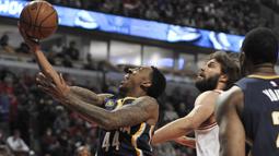 Ekpsresi pemain Indiana Pacers,  Jeff Teague (44) melakukan layup melewati hadangan pemain Chicago Bulls, Robin Lopez (tengah) pada lanjutan NBA basketball game di United Center, (26/12/2016).  (AP /Paul Beaty)