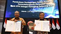 Wakil Direktur Utama PT Bank Tabungan Negara (Persero) Tbk, Nixon LP Napitupulu (kanan) dan Direktur Utama PT Kustodian Sentral Efek Indonesia (KSEI) Uriep Budhi Prasetyo (kiri) menunjukkan Perjanjian Kerja Sama  (PKS) mengenai  pemegang rekening KSEI di Jakarta (27/12/2022). (Liputan6.com)