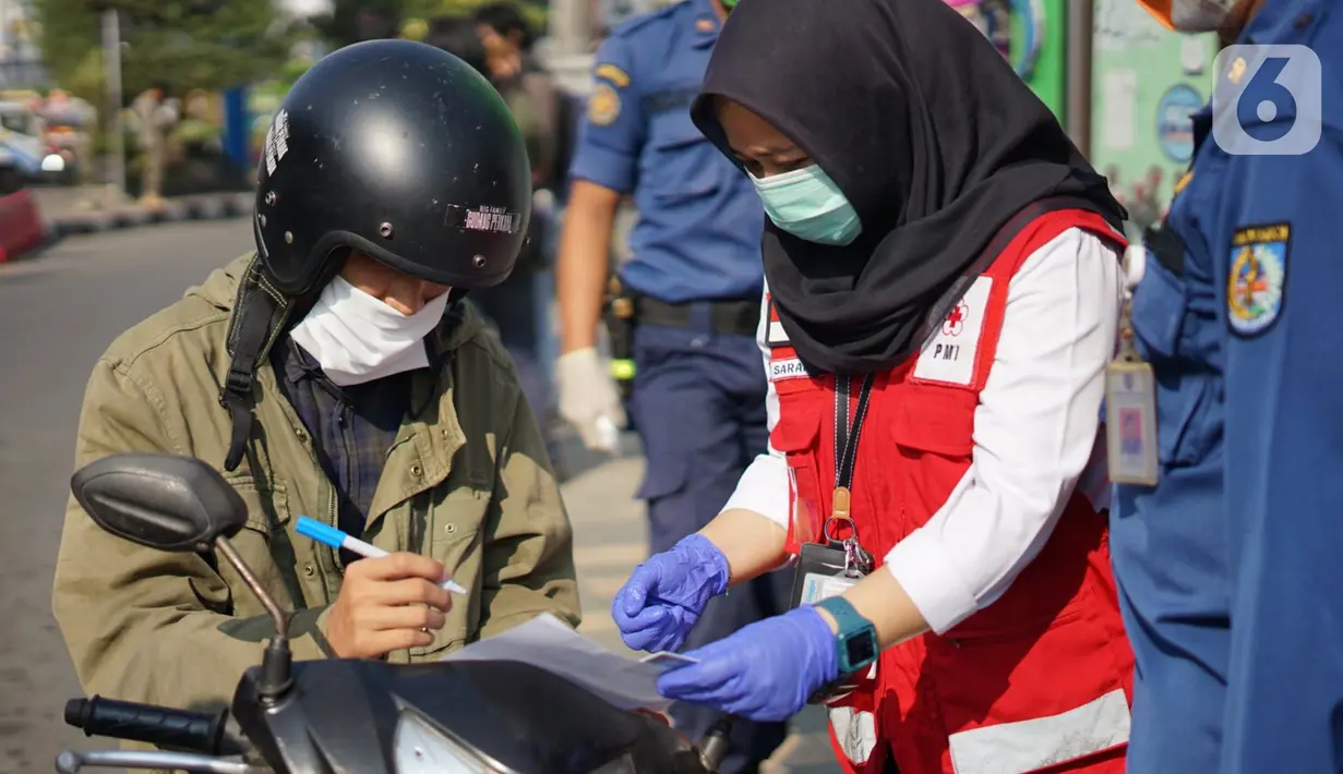 Petugas PMI melakukan sosialisasi penggunaan masker kepada pengendara sepeda motor di kawasan Depok, Jawa Barat, Senin (20/7/2020). Warga yang tidak mengenakan masker nantinya akan dikenai denda Rp 50 ribu atau sanksi sosial sesuai Perwali Nomor 45 tahun 2020. (Liputan6.com/Immanuel Antonius)