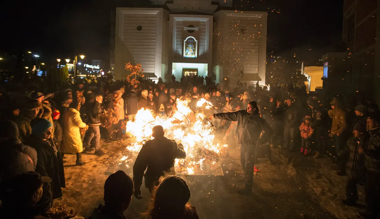 Sejumlah orang menghadiri upacara pembakaran cabang oak kering  atau Yule log selama perayaan Hari Natal Ortodoks di Belgrade, Serbia (6/1). Tradisi ini sudah berlangsung sejak lama dan turun temurun. (AFP/Oliver Bunic)