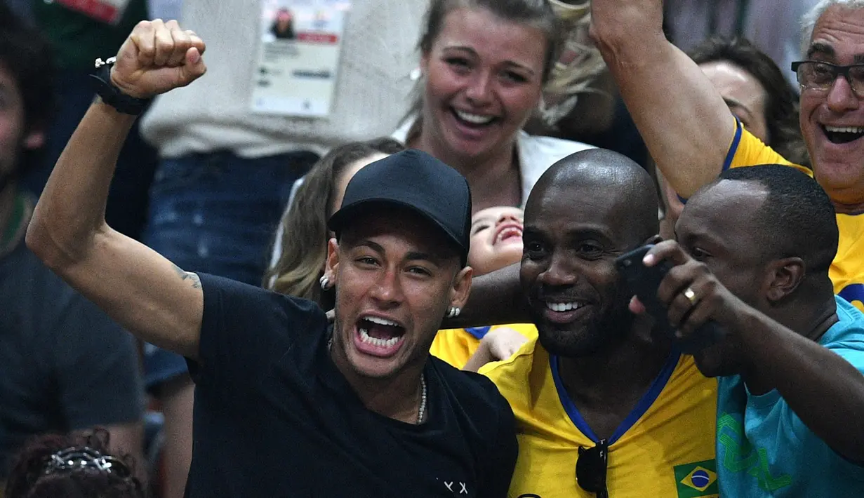Aksi Neymar (kir)  saat mendukung timnas voli Brasil berlaga pada final bola voli Olimpiade Rio 2016 melawan Italia di Stadion Maracanazinho, Rio de Janeiro, (21/8/2016). (AFP/Johannes Eisele)