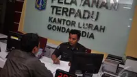 Petugas Kelurahan Gondangdia saat sedang menjelaskan pada warganya mengenai sistem Pelayanan Terpadu Satu Pintu (PTSP) di kantor lurah gondangdia, Jakarta, Senin (12/1/2015). (Liputan6.com/JohanTallo)