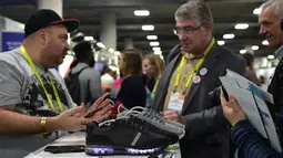 Pengunjung melihat sepatu lampu Wize & Ope di Consumer Electronic Show (CES), Las Vegas (5/1). sepatu ini dapat menyala dengan bantuan smartphone. (AFP Photo/Frederic J. Brown)