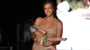 Model Mara Martin berjalan mengenakan pakaian renang Sports Illustrated selama Miami Swim Week 2018 di Florida, Minggu (15/8). Mara berjalan di landasan pacu memakai bikini gold, sambil menyusui putrinya Aria, yang berusia lima bulan. (AP/Lynne Sladky)
