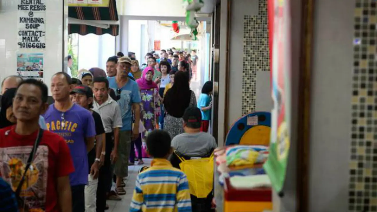 Orang-orang mengantre untuk mendapatkan bubur di kedai kopi Bedok North milik Elangovan 