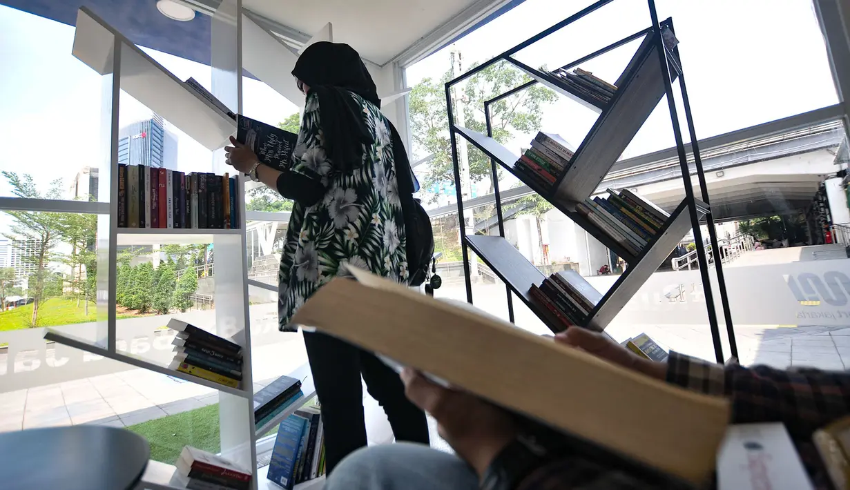 Warga membaca buku di Ruang Baca Jakarta, Dukuh Atas, Minggu (8/12/2019). Penumpang MRT dapat meminjam buku dari Ruang Baca Jakarta untuk dibaca selama perjalanan dan dikembalikan di stasiun tujuan. (merdeka.com/Iqbal Nugroho)