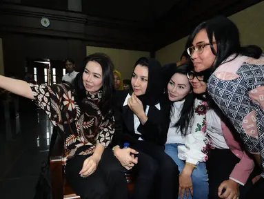 Bupati nonaktif Kutai Kartanegara, Rita Widyasari (kedua kiri) berswafoto bersama kerabatnya jelang mengikuti sidang perdana di Pengadilan Tipikor, Jakarta, Rabu (21/2). Sidang mendengar dakwaan Jaksa Penuntut Umum. (Liputan6.com/Helmi Fithriansyah)