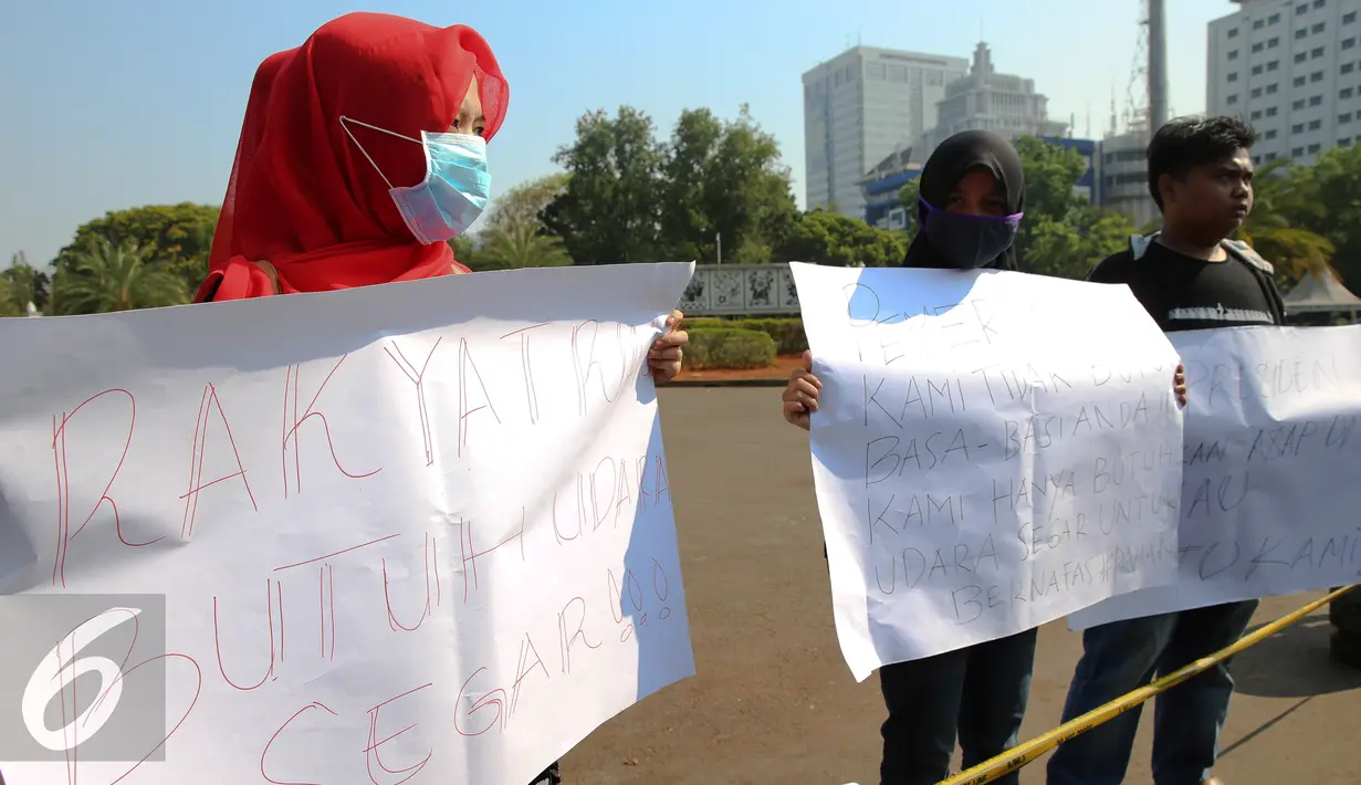 Mahasiswa Riau Jabodetabek membentangkan poster tuntutan saat unjuk rasa di depan Istana Merdeka, Jakarta, Jumat (18/9/2015). Dalam aksinya mereka mendesak pemerintah mencabut izin perusahan yang terlibat  dalam pembakaran. (Liputan6.com/Faizal Fanani)