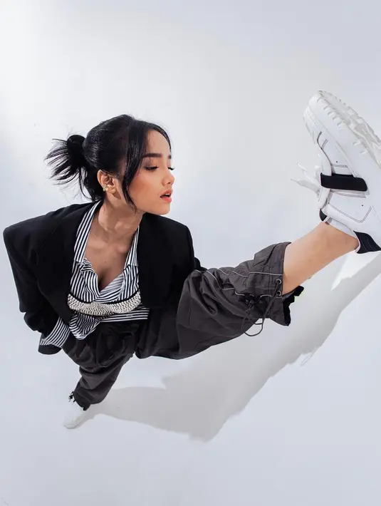Ia memilih mengenakan sepatu sporty yang menjadi aksen tersendiri dalam look-nya di sesi pemotretan tersebut. (Instagram @fuji_an)