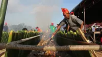 Bambu-bambu berisi beras ketan dengan campuran bahan lain dibakar oleh warga untuk pemecahan rekor pembakaran nasi bambu terbanyak. Tradisi Kuliner yang juga disebut nasi bambu itu dipamerkan dalam Festival Danau Poso tahun 2022. (Foto: Heri Susanto/ Liputan6.com).