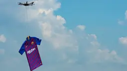 Barcelona menggunakan drone menerbangkan jersey terbarunya untuk musim 2018/2019 saat diperkenalkan di Montjuic Swimming Pool, 19 Mei 2018. Dilansir dari situs resminya, seragam kali ini menunjukkan penghormatan kepada kota Barcelona. (AFP/Josep LAGO)