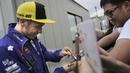 Pebalap Yamaha Movistar, Valentino Rossi, menyapa penggemarnya saat mendatangi paddock di Sirkuit Motegi, Tochigi Prefecture, Kamis (12/10/2017). MotoGP Jepang akan bergulir pada Minggu ini. (AP/Shizuo Kambayashi)