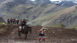 Seorang turis wanita menunggang kuda saat berwisata di Gunung Pelangi di Pitumarca, Peru (2/4). Rainbow Mountain atau Gunung Pelangi terbentuk sekitar 24 juta tahun lalu, akibat gempa tektonik. (AP Photo/Martin Mejia)