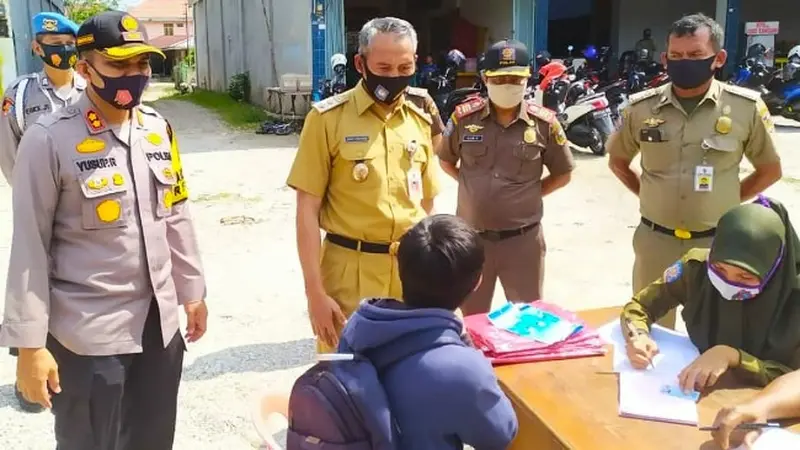 Petugas memberikan denda kepada warga Pekanbaru yang kedapatan tidak memakai masker.