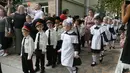 Orang tua mengambil foto ketika taruna muda menghadiri upacara pada hari pertama sekolah di salah satu sekolah Kadet terbaik, lyceum, di Kiev, Senin (3/9). Ukraina menandai Hari Pengetahuan, sebagai dimulainya tahun ajaran baru. (AP Photo/Efrem Lukatsky)