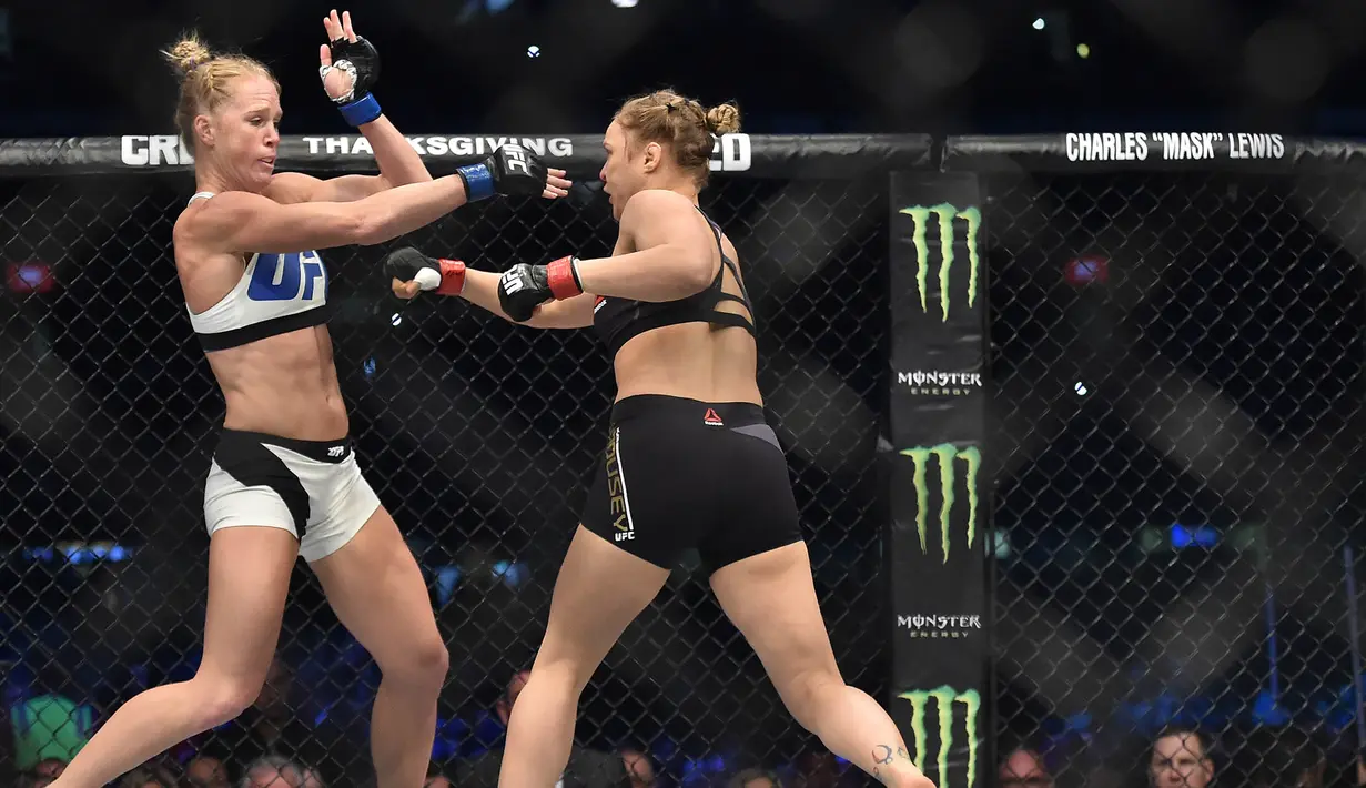 Ronda Rousey, bertukar pukulan dengan Holly Holm, pada pertarungan perebutan gelar juara kelas bantam UFC Women di Stadion Etihad, Melbourne, Minggu (15/11/2015). (AFP Photo/Paul Crock)