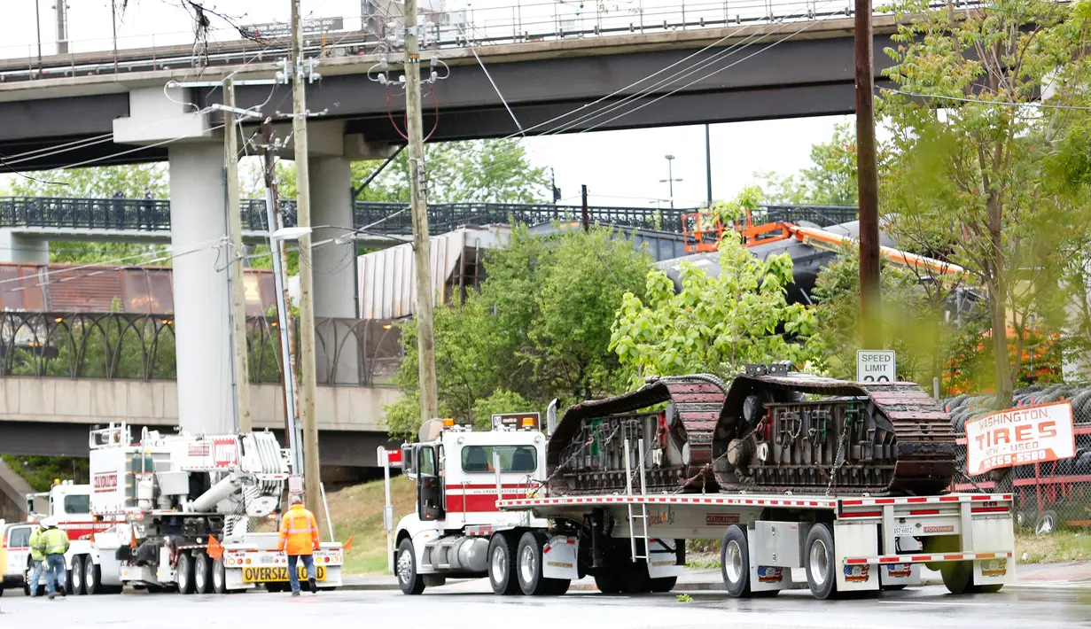 Petugas polisi dikerahkan ke lokasi kereta barang CSX yang keluar dari rel di bagian timur laut Washington, Minggu (1/5). Setidaknya sembilan gerbong kereta anjlok dengan tiga gerbong di antaranya menumpahkan zat kimia berbahaya ke rel. (Andrew BIRAJ/AFP)
