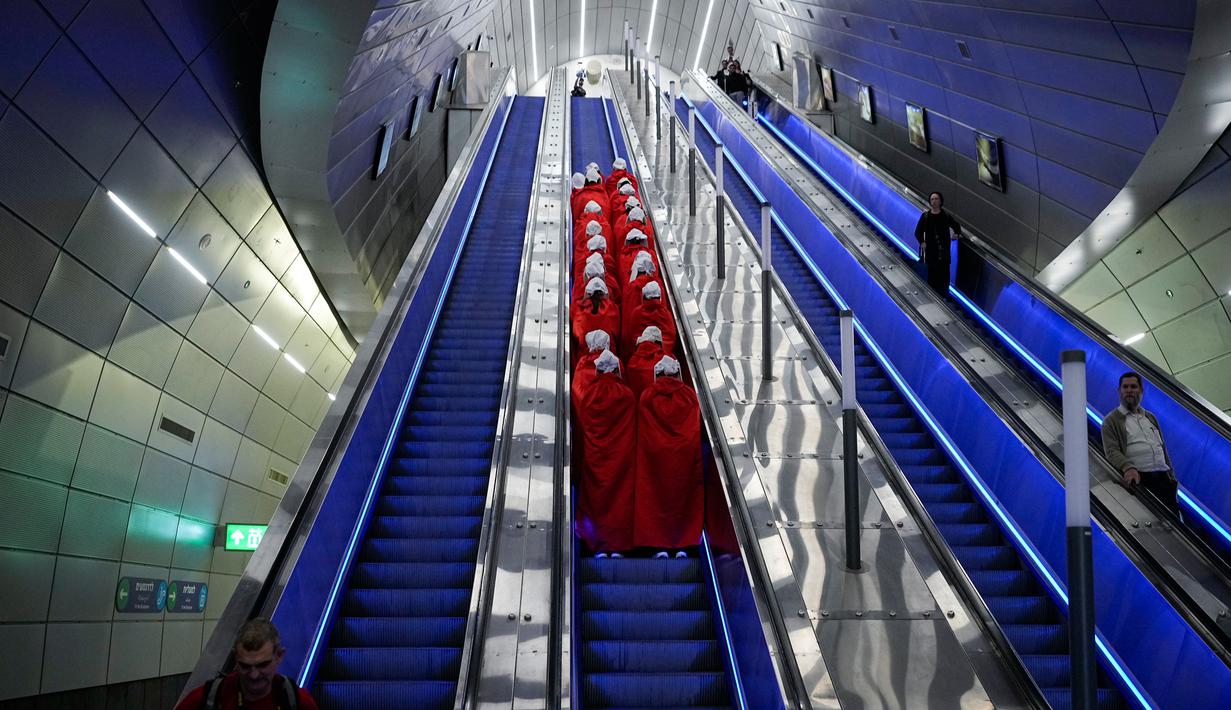 Pengunjuk rasa yang mendukung hak-hak perempuan berpakaian seperti karakter dari serial TV "The Handmaid's Tale" saat melakukan perjalanan untuk memprotes rencana pemerintah baru Perdana Menteri Benjamin Netanyahu untuk merombak sistem peradilan di sebuah stasiun kereta api di Yerusalem, Israel, 1 Maret 2023. Mengacu pada fenomena yang berkembang, harian Inggris The Guardian menggambarkan penampilan para pelayan sebagai salah satu simbol paling kuat dari protes feminis kontemporer. (AP Photo/Ohad Zwigenberg)