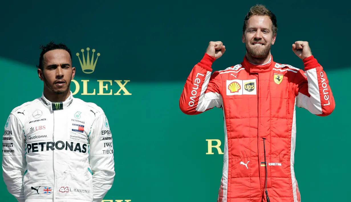 Gaya pembalap Ferrari, Sebastian Vettel (kanan) dan pembalap Mercedes Lewis Hamilton (kiri) usai memenangkan F1 GP di Sirkuit Silverstone, Inggris, Minggu (8/7). Vettel berhasil mengungguli Lewis Hamilton. (AP Photo/Luca Bruno)