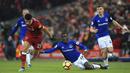 Gelandang Everton, Idrissa Gueye, terjatuh saat berusaha merebut bola dari striker Liverpool, Dominic Solanke, pada laga Premier League di Stadion Anfield, Minggu (10/12/2017). Laga bertajuk Derbi Merseyside itu berakhir imbang 1-1. (AP/Peter Byrne)