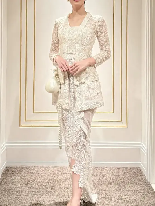 Renata tampil mengenakan kebaya putih lace warna putih dari Toton the Label dipadukan dengan bawahan kain berbordiran sambil membawa tas bulat putih ini. [@renata711]