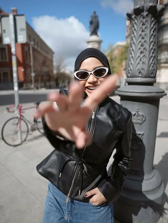 Gaya hijab Aurel juga tak kalah menarik. Ia memilih hijab hitam polos yang dikenakan rapi dan clean, menciptakan kesan simpel namun tetap modis. Aksesori-nya pun mendukung keseluruhan outfit: kacamata cat-eye putih memberikan sentuhan retro yang playful, sementara tas bahu berwarna cokelat muda dengan rantai emas menambahkan aksen mewah tanpa terkesan berlebihan. [@aurelie.hermansyah].