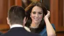 Kate Middleton juga melengkapi penampilannya dengan anting-anting mutiara dan kristal J.Crew yang sudah habis terjual, serta tas tangan Jenny Packham berhiaskan permata.  (AP Photo/Kin Cheung)