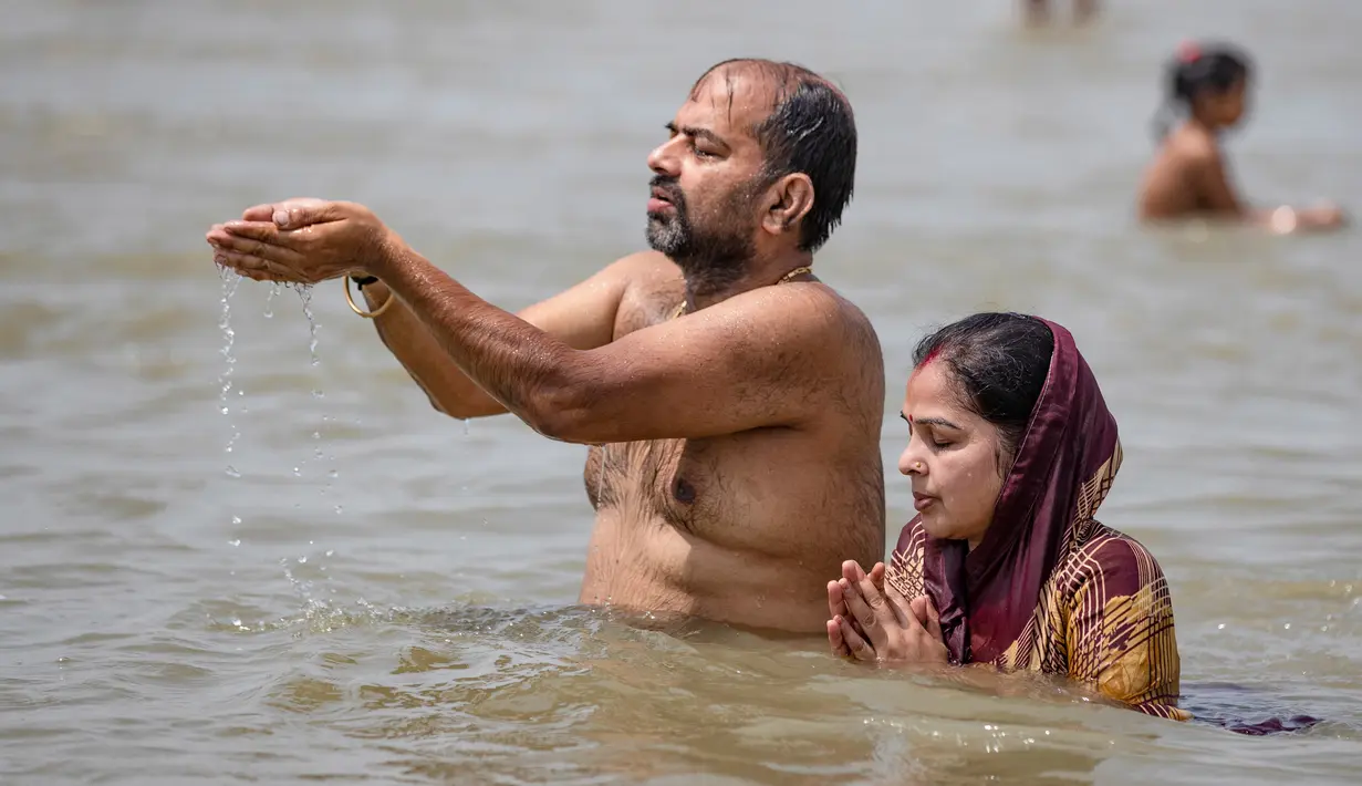 Umat Hindu berdoa di Sungai Gangga, selama festival Ganga Dussehra, di Prayagraj, India (1/6/2020). Ratusan umat Hindu melakukan pencucian suci meskipun jemaat di tempat-tempat keagamaan terus dilarang selama penguncian coronavirus nasional. (AP Photo/Rajesh Kumar Singh)