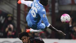 Penyerang AC Milan, Luiz Adriano (bawah) berebut bola dengan bek Napoli, kalidou koulibaly pada Lanjutan liga Italia di Stadion San Siro (4/10/2015). AC Milan Kalah telak atas Napoli dengan skor 0-4. (REUTERS/Giorgio Perottino)