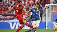 Bek Timnas Indonesia, Jordi Amat menghalau bola dari jangkauan striker Timnas Jepang, Ayase Ueda dalam laga terakhir Grup D Piala Asia 2023, Rabu (24/1/2024), malam WIB di Stadion Al Thumama, Doha, Qatar. (AFP/Hector Retamal)