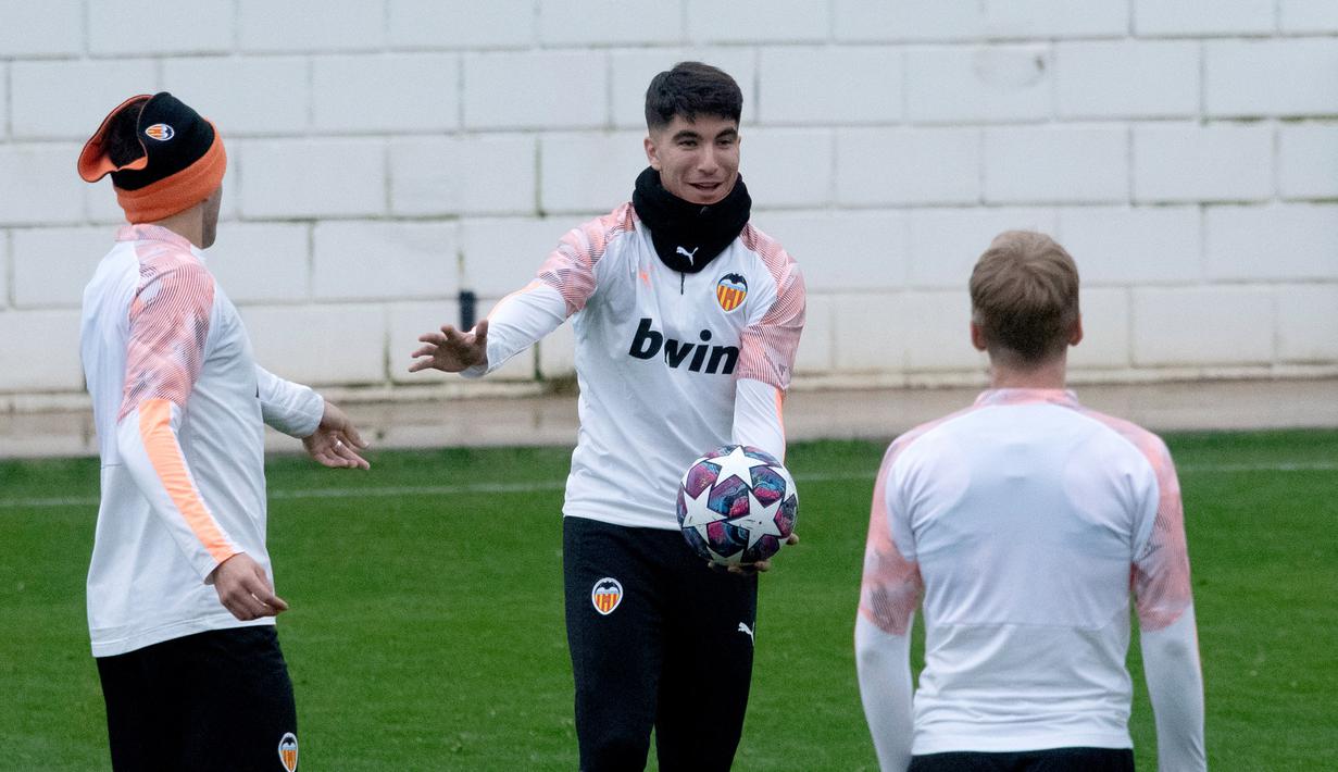 Pemain Valencia Carlos Soler (tengah) memegang bola saat sesi latihan di Paterna Sports City, Paterna, Spanyol, Selasa (18/2/2020). Valencia akan menghadapi Atalanta pada leg pertama babak 16 besar Liga Champions di San Siro, 20 Februari 2020 dini hari WIB. (JOSE JORDAN/AFP)