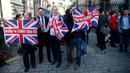 Pendukung Brexit mengibarkan bendera Inggris setelah melihat hasil penghitungan sementara referendum Inggris yang menunjukkan mayoritas rakyat Inggris memilih “Brexit” alias keluar dari Uni Eropa, di London, Kamis (23/6). (REUTERS/Neil Hall)