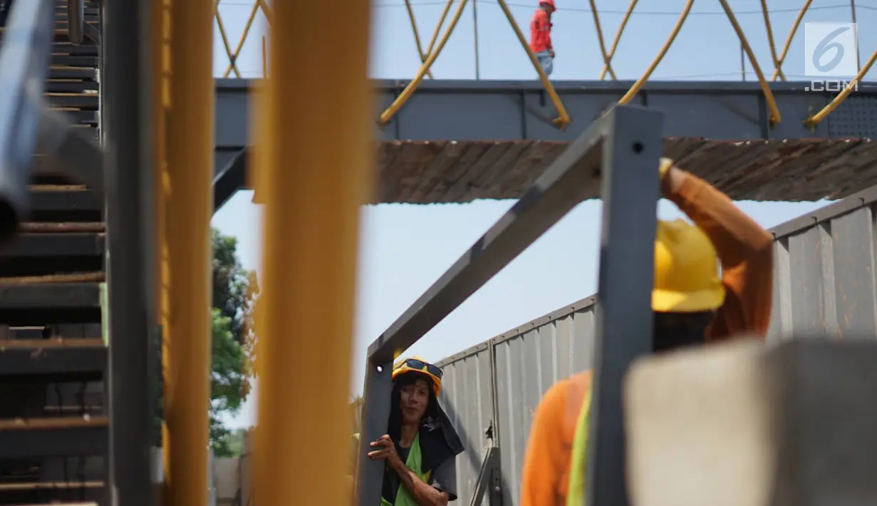 Pekerja menggarap proyek pembangunan Jembatan Penyebaran Orang (JPO) Pasar Minggu di Jakarta Selatan, Kamis (26/9/2019). JPO berdesain artistik senilai Rp 7 miliar tersebut ditargetkan rampung pengerjaannya pada Desember 2019 mendatang. (Liputan6.com/Immanuel Antonius)