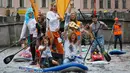 Orang-orang mengenakan kostum saat mendayung "paddle board" di Sungai Fontanka pada festival SUP (Stand Up Paddle)-Surfing di St.Petersburg, Rusia, Minggu (12/8). Dalam paddling, papan digerakkan dengan cara mendayung sambil berdiri. (AP/Dmitri Lovetsky)