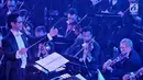 Konduktor Musik Addie MS memimpin pertunjukan konser outdoor bertema Symphony Under The Stars di Lippo Mall Kemang, Jakarta, Sabtu (28/7). Movie Fest merupakan tema musik yang akan ditampilkan pada kegiatan musik kali ini. (Liputan6.com/Fery Pradolo)