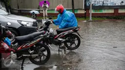 Pengendara berusaha menyalakan kendaraannya yang mogok akibat melintasi air banjir di jalan Gunung, Jakarta, Selasa (21/2). Hujan deras sejak malam tadi, membuat sejumlah wilayah Jakarta tergenang air banjir. (Liputan6.com/Faizal Fanani)