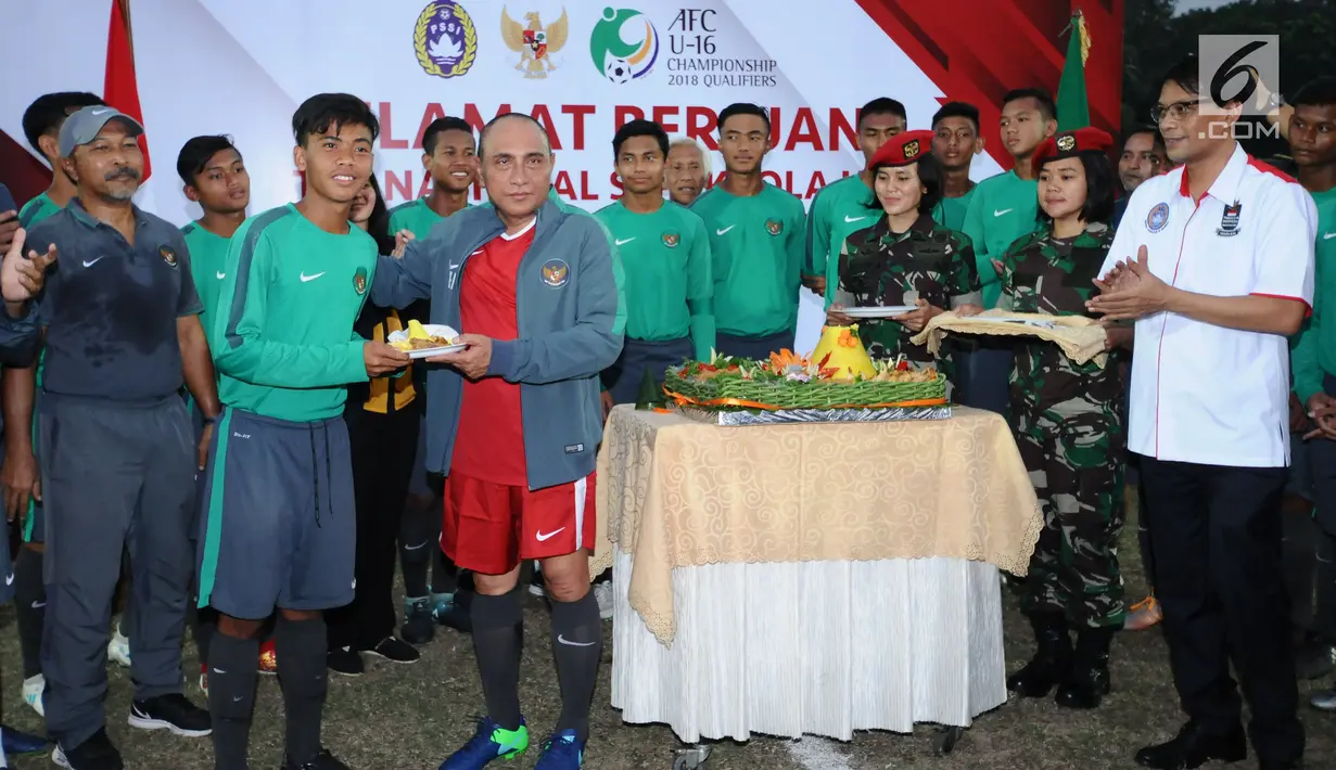 Ketua Umum PSSI, Edy Rahmayadi (kaos merah) memberi potongan tumpeng pada pemain Timnas Indonesia U-16, David Maulana saat pelepasan di Lapangan Atang Sutresna, Jakarta, Rabu (13/9). (Liputan6.com/Helmi Fithriansyah)