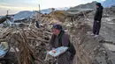 Sejumlah wanita berdiri di atas reruntuhan rumah mereka di desa Yaylakonak distrik Adiyaman, Turki, Minggu (19/2/2023). Gempa bumi berkekuatan 7,8 magnitudo melanda dekat Gaziantep, Turki, pada dini hari tanggal 6 Februari, diikuti oleh gempa susulan berkekuatan 7,5 magnitudo setelah tengah hari. Gempa bumi tersebut menyebabkan kehancuran yang meluas di Turki Selatan dan Suriah Utara dan telah menewaskan lebih dari 40.000 orang. (BULENT KILIC/AFP)