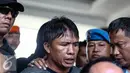Tersangka Ridwan Sitorus alias Ius Pane (54), tiba di Bandara Halim Perdana Kusumah, Minggu (1/1). Ius menjadi tersangka atas kasus perampokan dan pembunuhan yang terjadi di rumah mewah Pulomas. (Liputan6.com/Faizal Fanani)