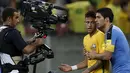 Penyerang Uruguay, Luis Suarez (kanan) saat mencoba mengontrol kemarahan rekan setimnya di Barcelona, Neymar, Stadion Arena Pernambuco, Brasil, (25/3). Pertandingan ini akhirnya berkesudahan dengan skor 2-2. (REUTERS / Paulo Whitaker)
