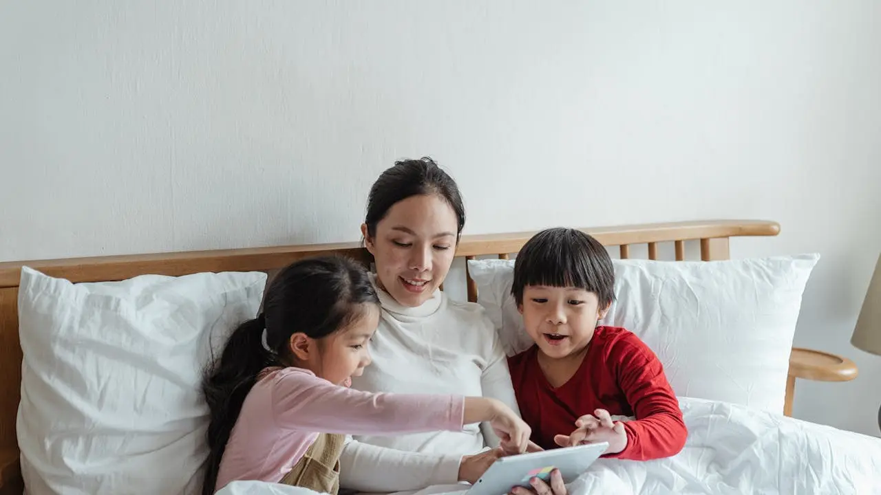 Ibu membacakan dongeng di kasur untuk anak (Pexels)