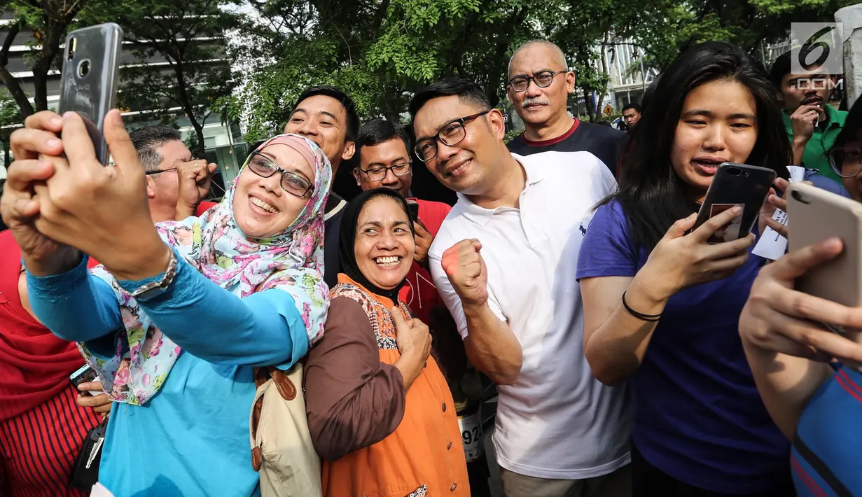 Gubernur Jawa Barat Ridwan Kamil berswafoto bersama warga saat Family Day Artha Graha Peduli (AGP) di Pasar Akhir Pekan SCBD, Jakarta, Minggu (25/11). Kehadiran pria yang akrab disapa Emil itu menjadi rebutan warga berswafoto. (Liputan6.com/Fery Pradolo)