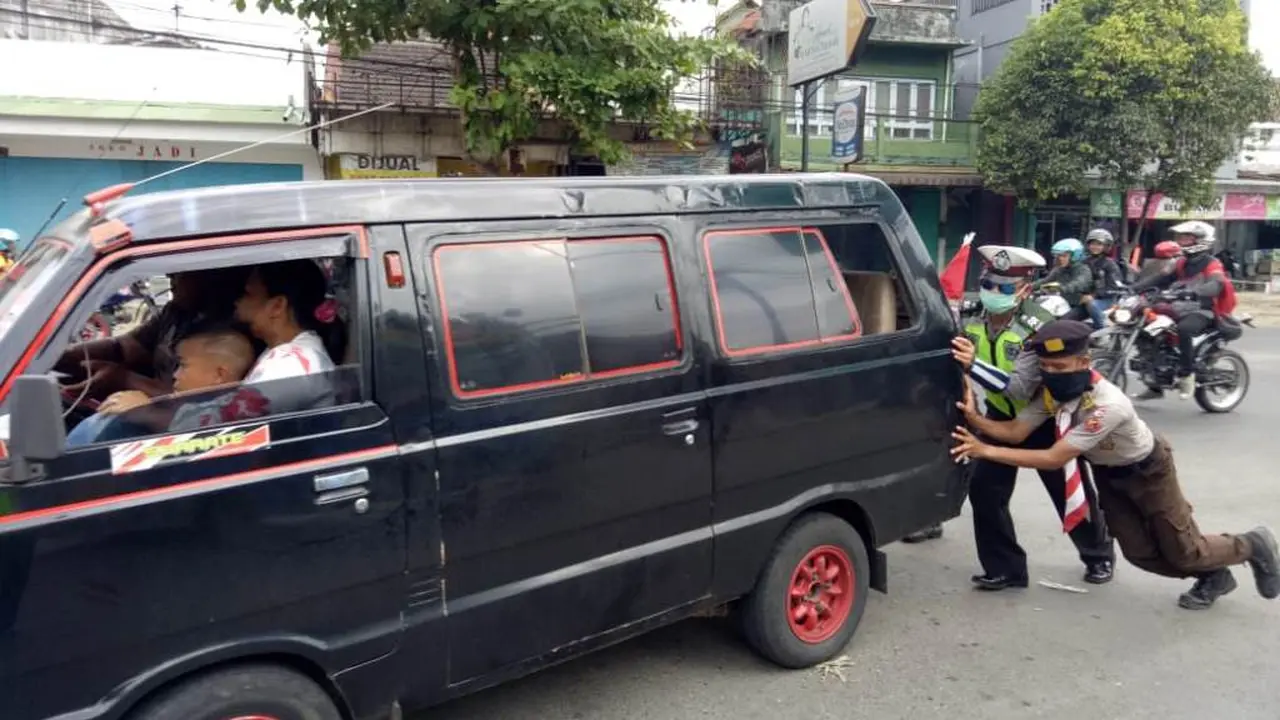 Relawan dan polisi mendorong mobil pemudik yang mogok di Gombong, Kebumen pada arus mudik lebaran 2018, Selasa, 12 Juni 2018. (Liputan6.com/Polres Kebumen/Muhamad Ridlo)