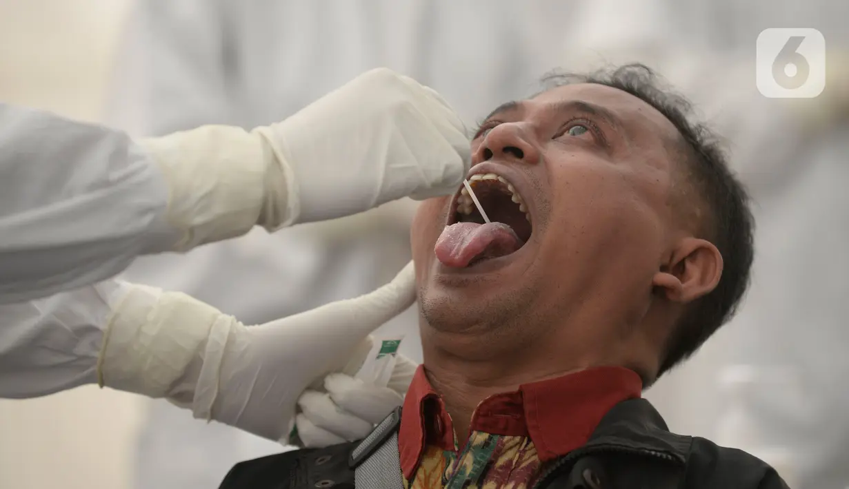 Petugas medis mengambil sempel lendir salah satu peserta test SWAB massal gratis di halaman Dinas Kesehatan Tangeramg Selatan, Banten, Minggu (30/8/2020). Test Swab gratis tersebut diikuti 750 orang untuk pencegahaan penyebaran Covid-19. (merdeka.com/Dwi Narwoko)