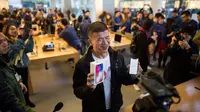 Ekspresi seorang pembeli saat berpose dengan iPhone X baru di sebuah showroom Apple di Beijing, China (3/11). (AFP Photo/Fred Dufour)