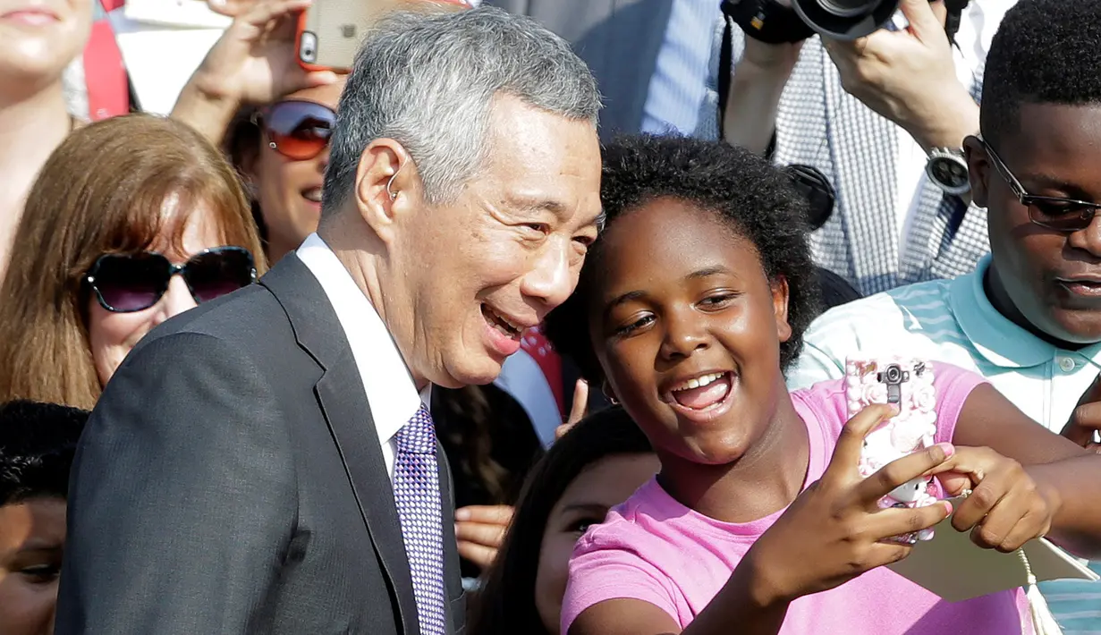PM Singapura, Lee Hsien Loong berwefie dengan seorang warga pada upacara penyambutan kedatangannya di Gedung Putih, Washington, Selasa (2/8). (REUTERS/Joshua Roberts)