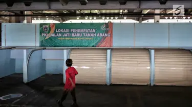 Seorang anak bermain dekat kios penampungan pedagang kaki lima (PKL) yang kosong di Blok F Tanah Abang, Jakarta, Kamis (31/1). Hingga kini tempat untuk PKL yang tidak memperoleh lapak di skybridge Tanah Abang itu tak diminati. (Liputan6.com/Faizal Fanani)